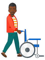 Image showing Man pushing wheelchair.