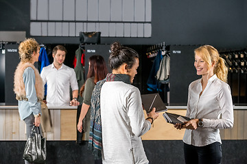 Image showing Friends Standing By Bag Deposit Counter In Cafe