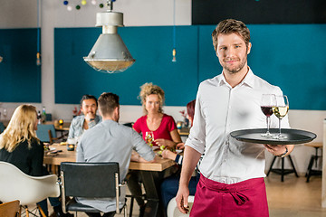 Image showing Confident Waiter Holding Tray At Restaurant