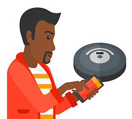 Image showing Man with robot vacuum cleaner.