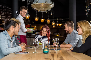 Image showing Waiter Serving Food To Customers At Table In Cafe