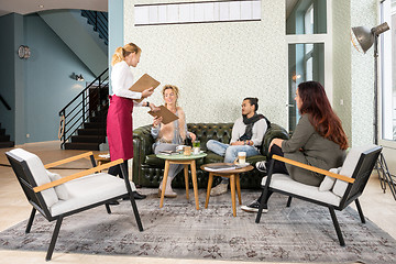 Image showing Waitress Presenting Menu To Customer In Cafe