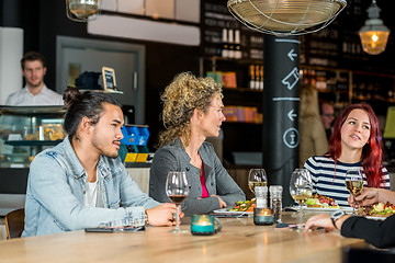 Image showing Friends Conversing While Having Food At Restaurant