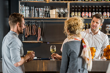 Image showing Bartender Talking With Customers At Bar Counter