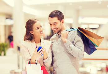 Image showing couple with smartphone and shopping bags in mall