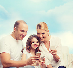 Image showing happy family with smartphones