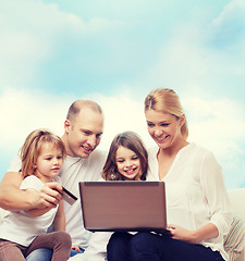 Image showing happy family with laptop computer and credit card