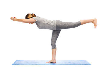 Image showing woman making yoga warrior pose on mat