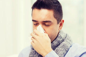 Image showing close up of ill man with flu blowing nose at home