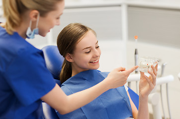 Image showing dentist showing jaw layout to happy girl patient