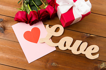 Image showing close up of gift box, red roses and greeting card