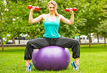 Image showing Sports girl  exercise with dumbbells in the park