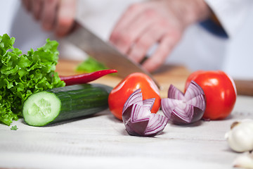 Image showing Chef cutting a green lettuce his kitchen