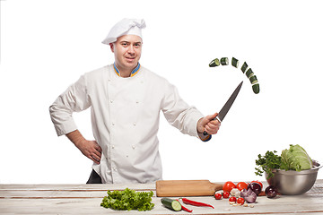 Image showing Chef cutting a green cucumber in his kitchen