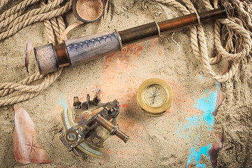 Image showing set of nautical instruments, lying on the sand and old map. concept adventure