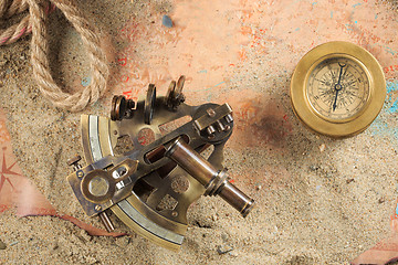 Image showing set of nautical instruments, lying on the sand and old map. concept adventure