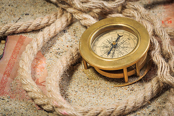 Image showing set of nautical instruments, lying on the sand and old map. concept adventure