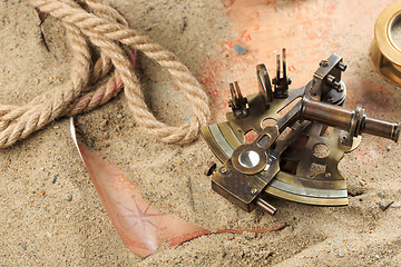 Image showing set of nautical instruments, lying on the sand and old map. concept adventure