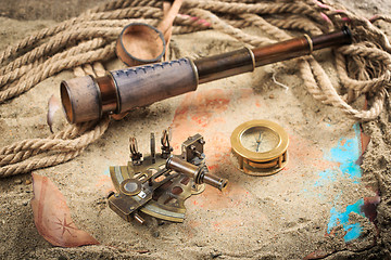 Image showing set of nautical instruments, lying on the sand and old map. concept adventure