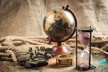 Image showing set of nautical instruments, lying on the sand and old map. concept adventure