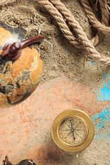 Image showing set of nautical instruments, lying on the sand and old map. concept adventure