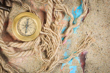 Image showing set of nautical instruments, lying on the sand and old map. concept adventure