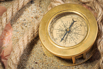 Image showing set of nautical instruments, lying on the sand and old map. concept adventure