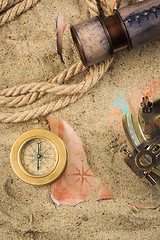 Image showing set of nautical instruments, lying on the sand and old map. concept adventure