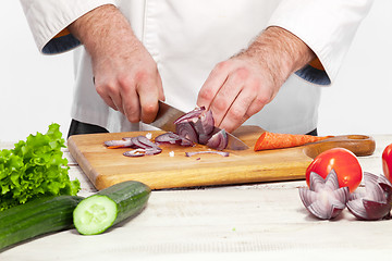 Image showing Chef cutting a onion on his kitchen