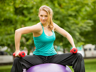 Image showing Sports girl  exercise with dumbbells in the park