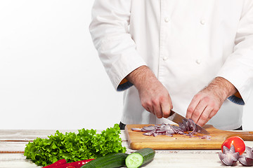Image showing Chef cutting a onion on his kitchen