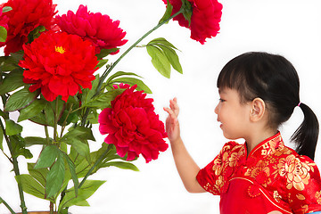 Image showing Chinese little girl wearing in Red posing with flowers