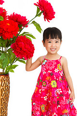 Image showing Chinese little girl wearing in Red posing with flowers