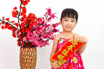 Image showing Chinese little girl pising holding  Spring festival couplets