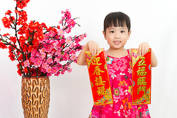 Image showing Chinese little girl pising holding  Spring festival couplets