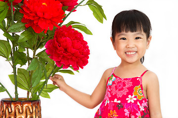 Image showing Chinese little girl wearing in Red posing with flowers