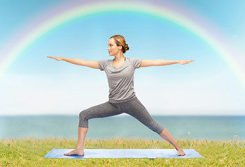 Image showing woman making yoga warrior pose on mat