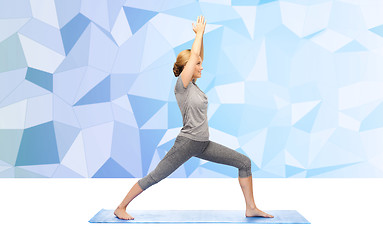 Image showing woman making yoga warrior pose on mat