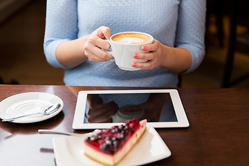 Image showing close up of hands with coffee, tablet pc and cake