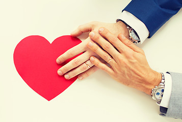 Image showing close up of male gay couple hands with red heart