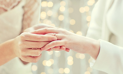 Image showing close up of lesbian couple hands with wedding ring