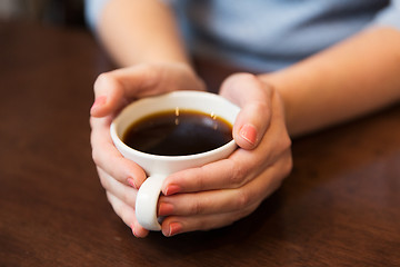 Image showing close up of woman holding hot black coffee cup