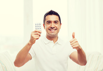 Image showing happy man with pack of pills showing thumbs up
