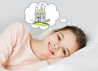 Image showing smiling girl lying in bed and dreaming of castle