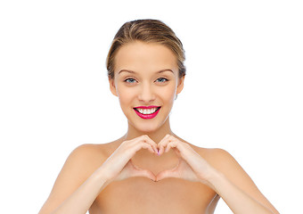 Image showing smiling young woman showing heart shape hand sign