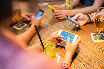 Image showing close up of hands with smartphones at restaurant