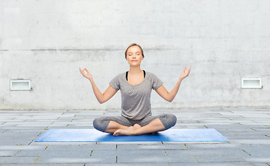 Image showing woman making yoga meditation in lotus pose on mat