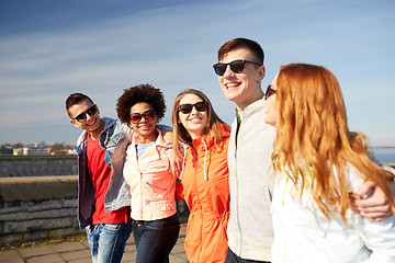 Image showing happy teenage friends walking along city street