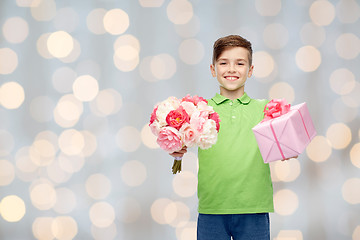 Image showing happy boy holding flower bunch and gift box
