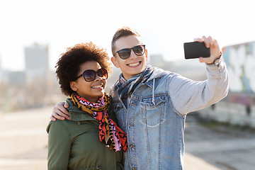 Image showing happy teenage friends in shades taking selfie